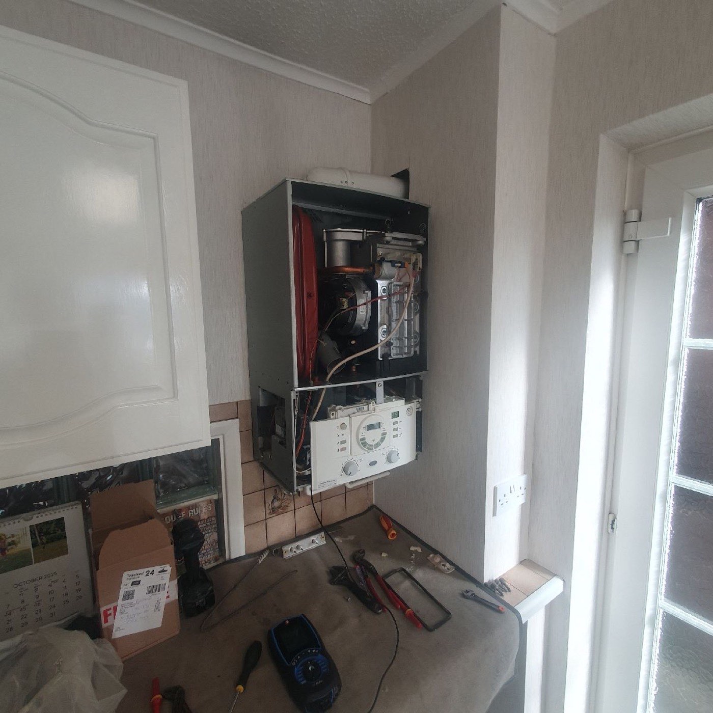 Old boiler and pipework in a Kent utility room before replacement